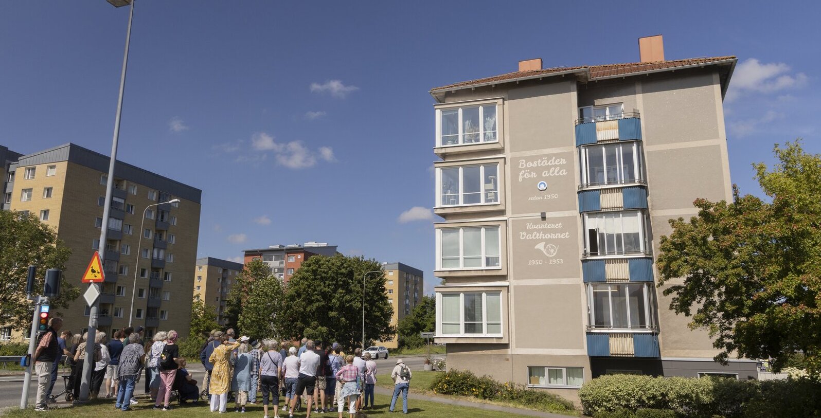 En stadsvandringsgrupp beundrar fasadkonsten.